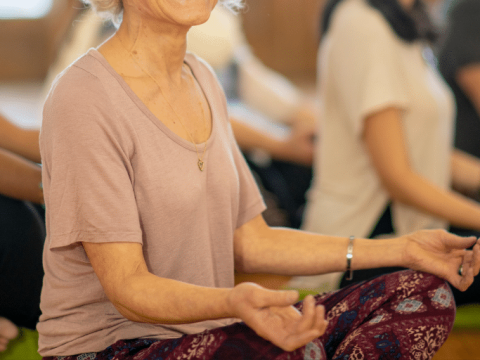 Women sitting on the floor cross-legged in a yoga pose