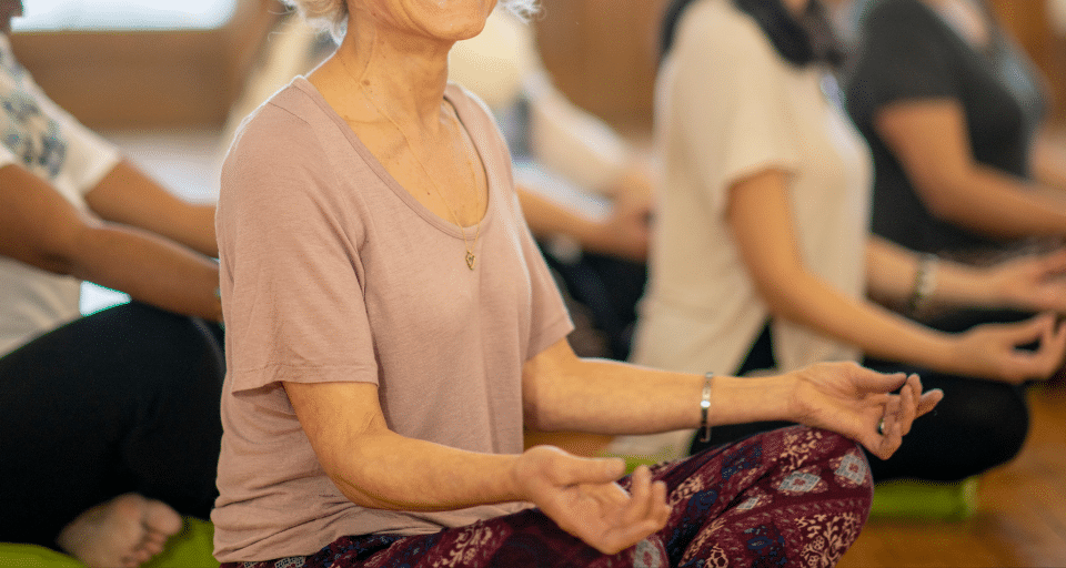 Women sitting on the floor cross-legged in a yoga pose