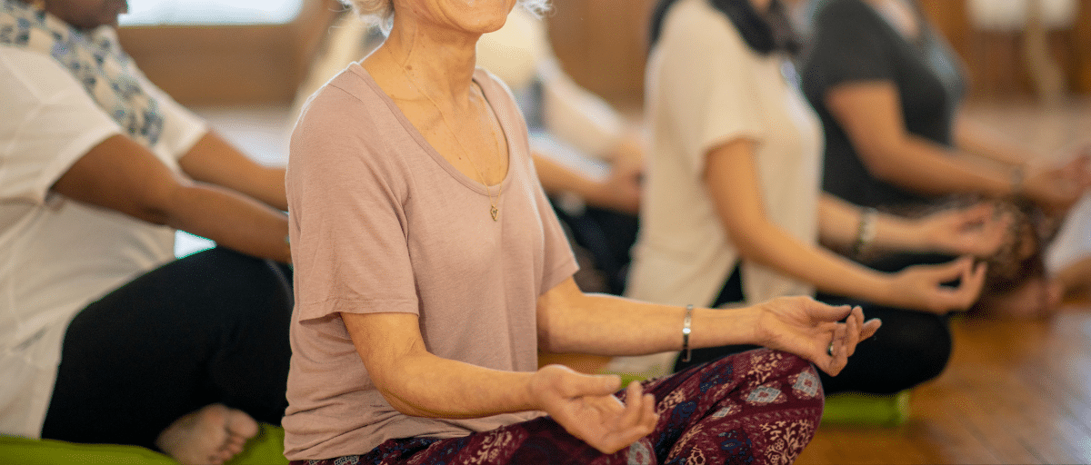 Women sitting on the floor cross-legged in a yoga pose