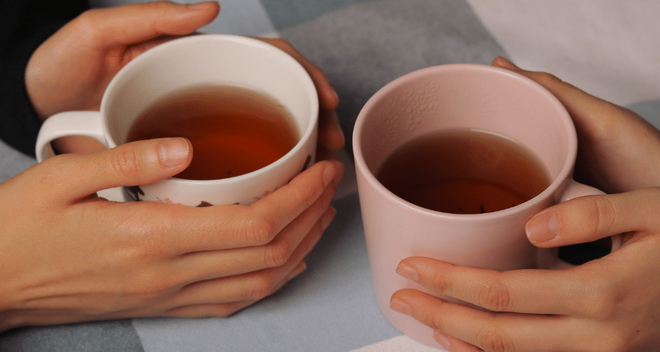 Hands cupping warm drinks