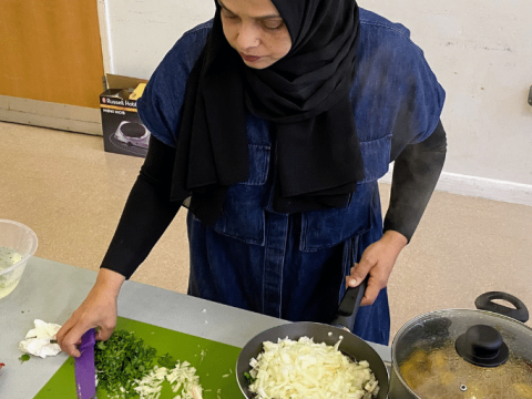 Session leader, Moni, is preparing ingredients to cook