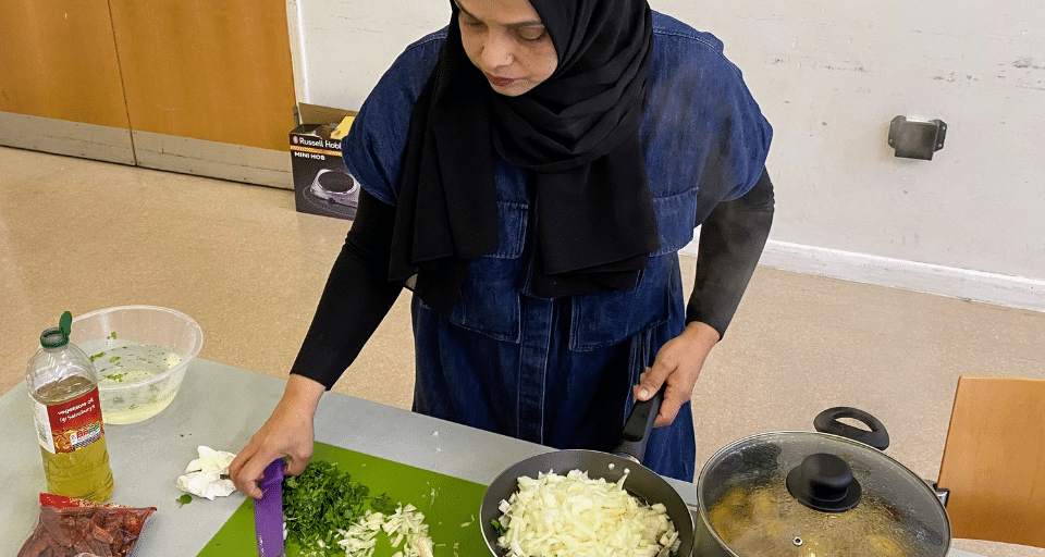 Session leader, Moni, is preparing ingredients to cook