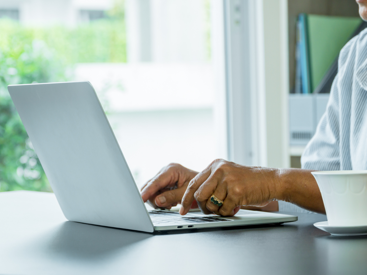 An older woman getting digital skills help on a laptop