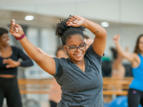 A woman energetically dancing with her arms in the air