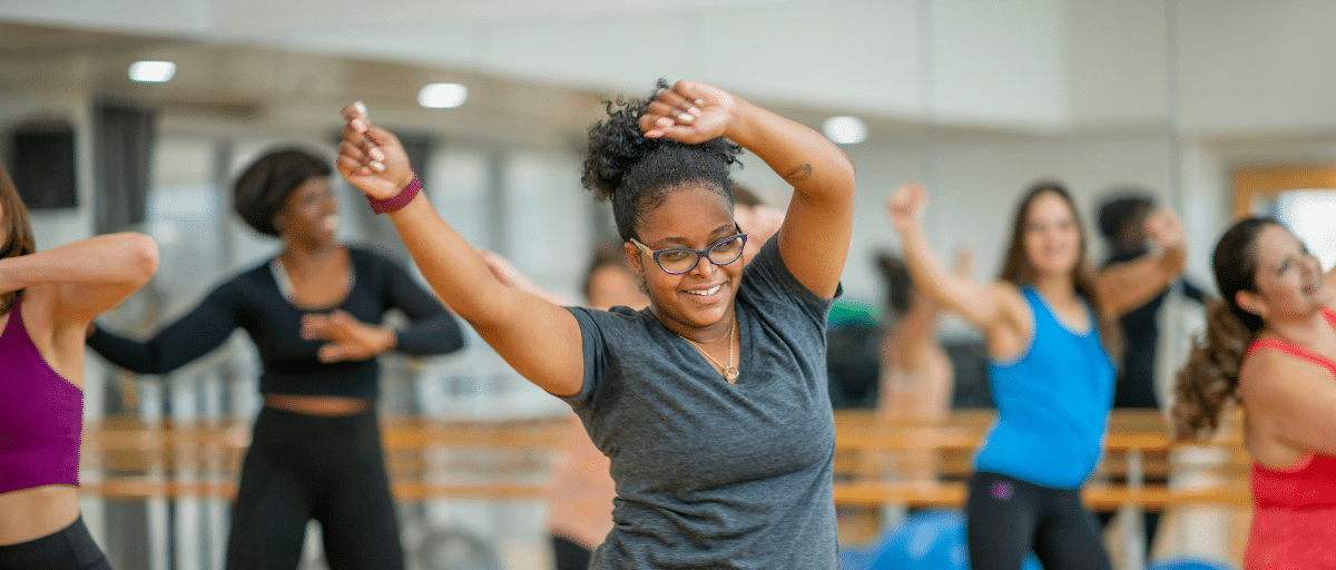A woman energetically dancing with her arms in the air