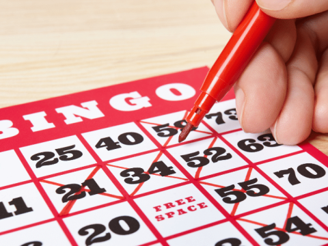 Crossing numbers off a bingo card at Lucky Lines bingo in Poplar