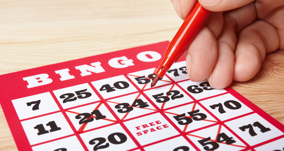 Crossing numbers off a bingo card at Lucky Lines bingo in Poplar