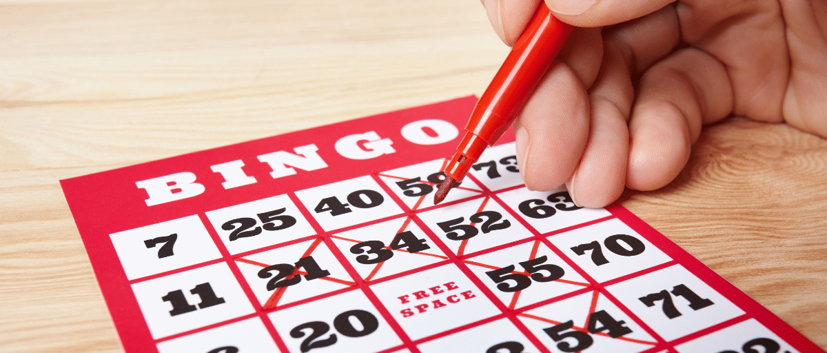 Crossing numbers off a bingo card at Lucky Lines bingo in Poplar