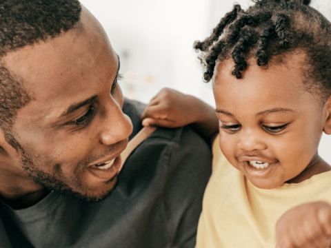 A dad and his young daughter play together