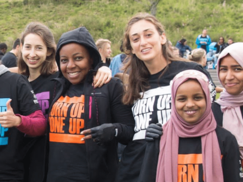 A group of people outside in the park, smiling and wearing Our Parks branded tshirts.