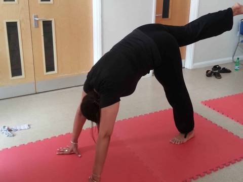 A woman doing a downward dog yoga pose on a yoga mat