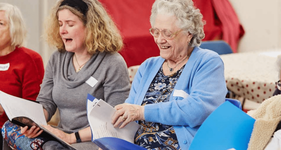 A group of older people are happily singing together
