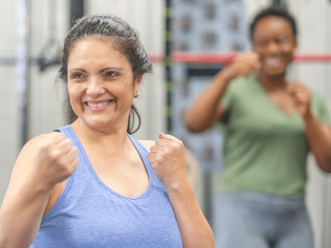Two women taking part in a Boxercise class at Island House Community Centre, with their fists raised ready to jab