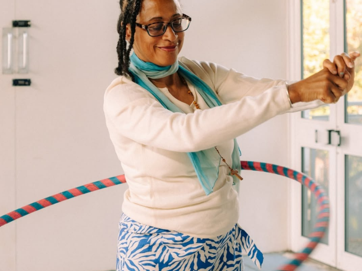 Woman hula-hooping and smiling