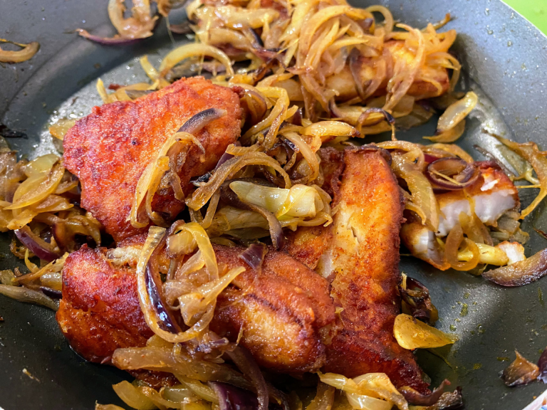 Image of fish and onions being cooked in a pan