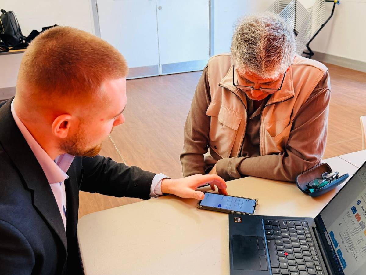ELBA volunteer Taylor showing session attendee how to set up a NHS Account Login