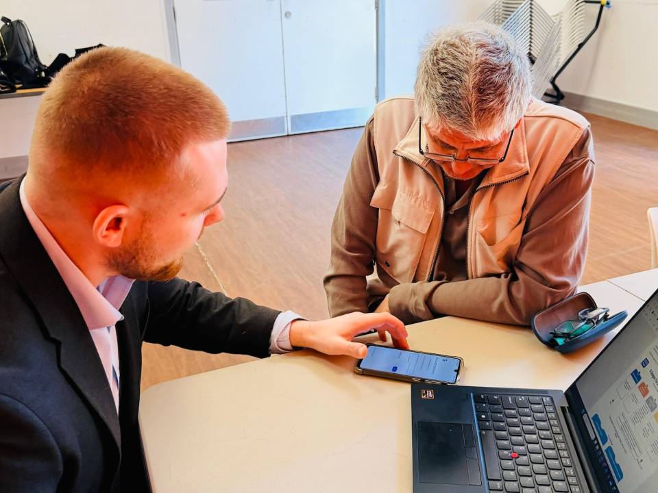ELBA volunteer Taylor showing session attendee how to set up a NHS Account Login