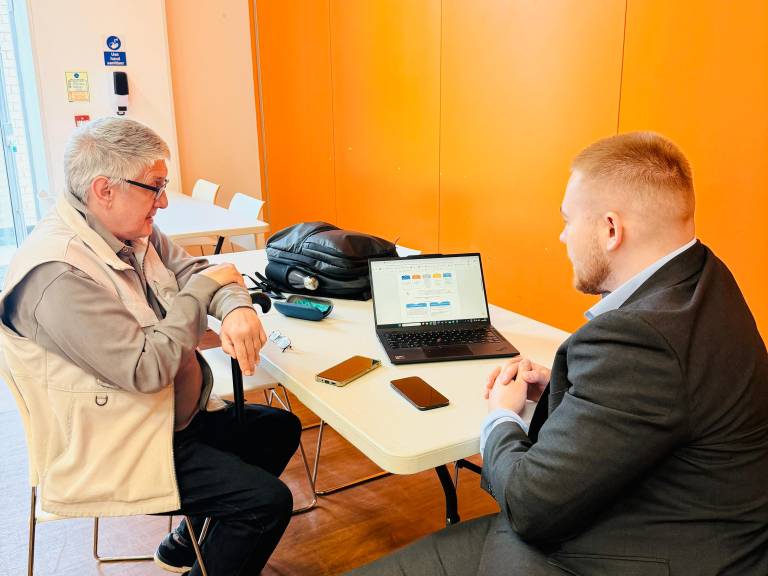 A Tap Into Health volunteer demonstrates how to use the NHS App to order repeat prescriptions