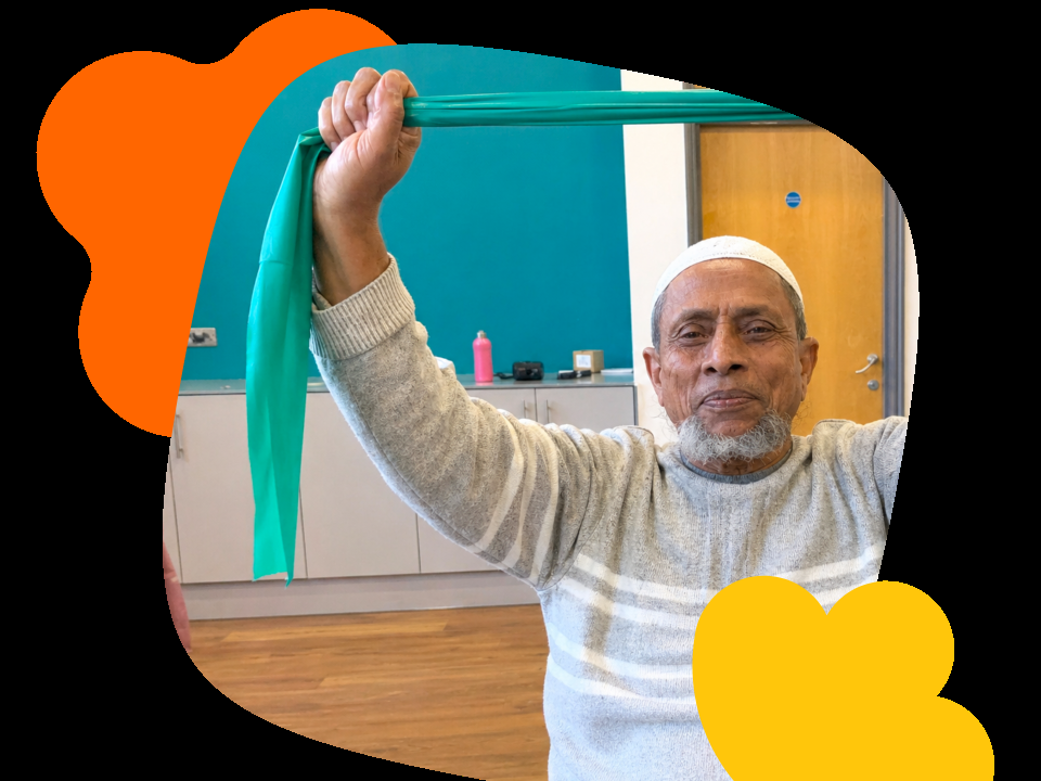 A man stretches a resistance band above his head during a seated exercise class